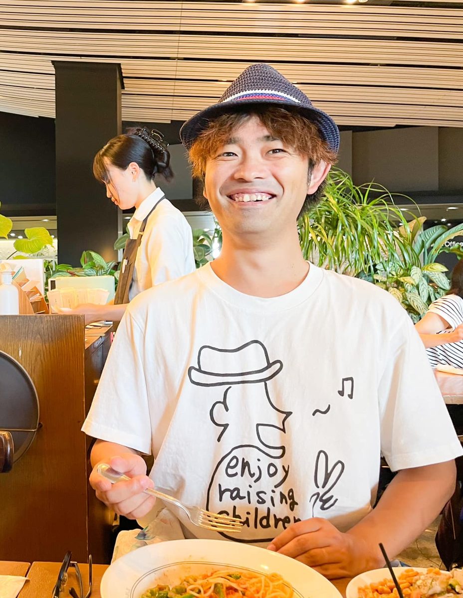 ランチ会で自然に笑うじゅんコーチ。Tシャツにはenjoy raising childrenの文字